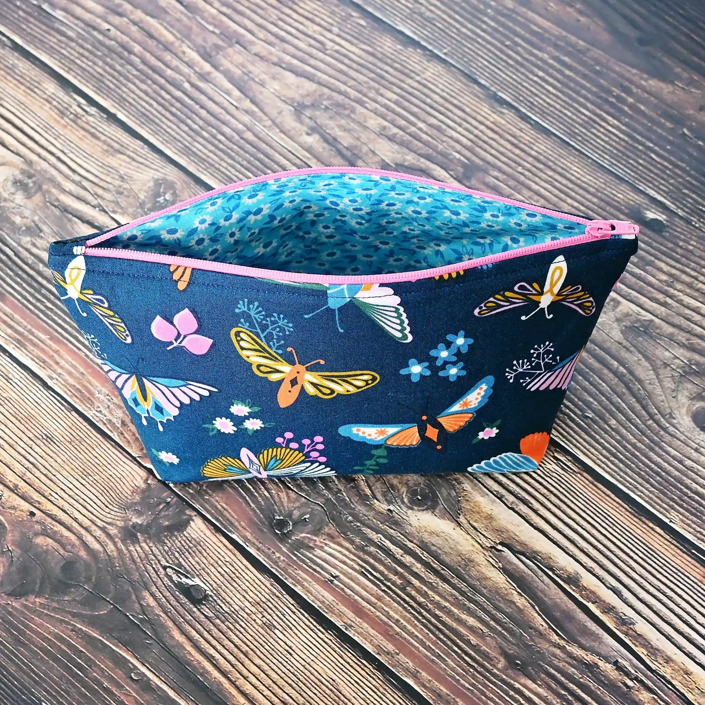 Beautiful navy accessory pouch with butterflies.  Lined in a pretty aqua floral and adorned with a pink zipper.  Made in fabrics by the Ruby Star Society.  Handmade in Canada by Yellow Petal Handmade.