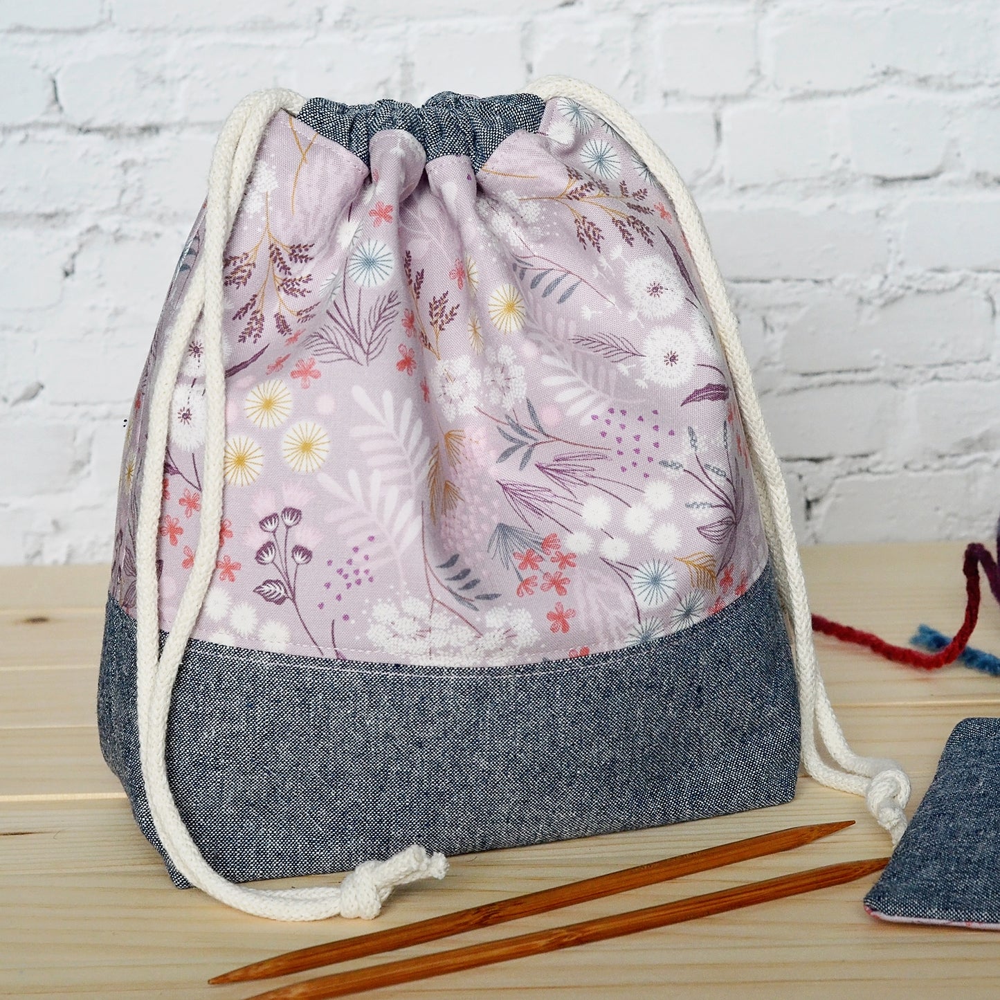 Mauve floral and indigo drawstring linen knitting project bag and pouch set.