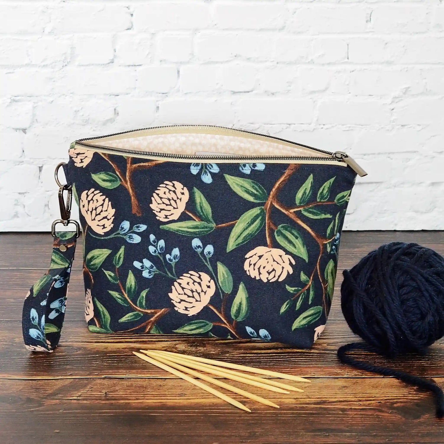Navy canvas pouch made from peonies fabric from Rifle Paper Co and lined with a pale blush and white flowered cotton.  Comes with removable strap.  Made in Canada by Yellow Petal Handmade.