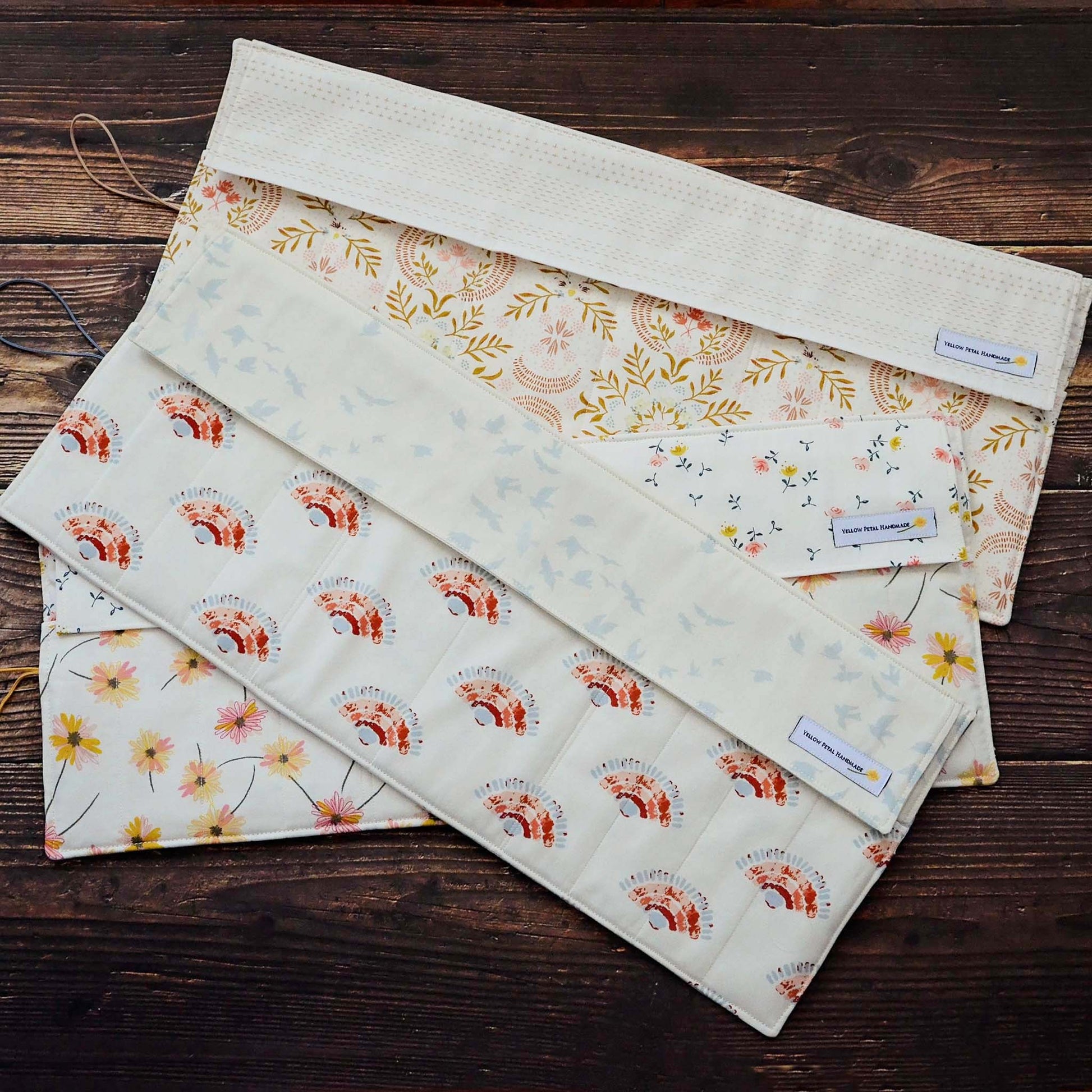 Quilted knitting needle wraps in premium Art Gallery Fabric.  Three different designs, all with an elastic and button closure.  Made in Canada by Yellow Petal Handmade.