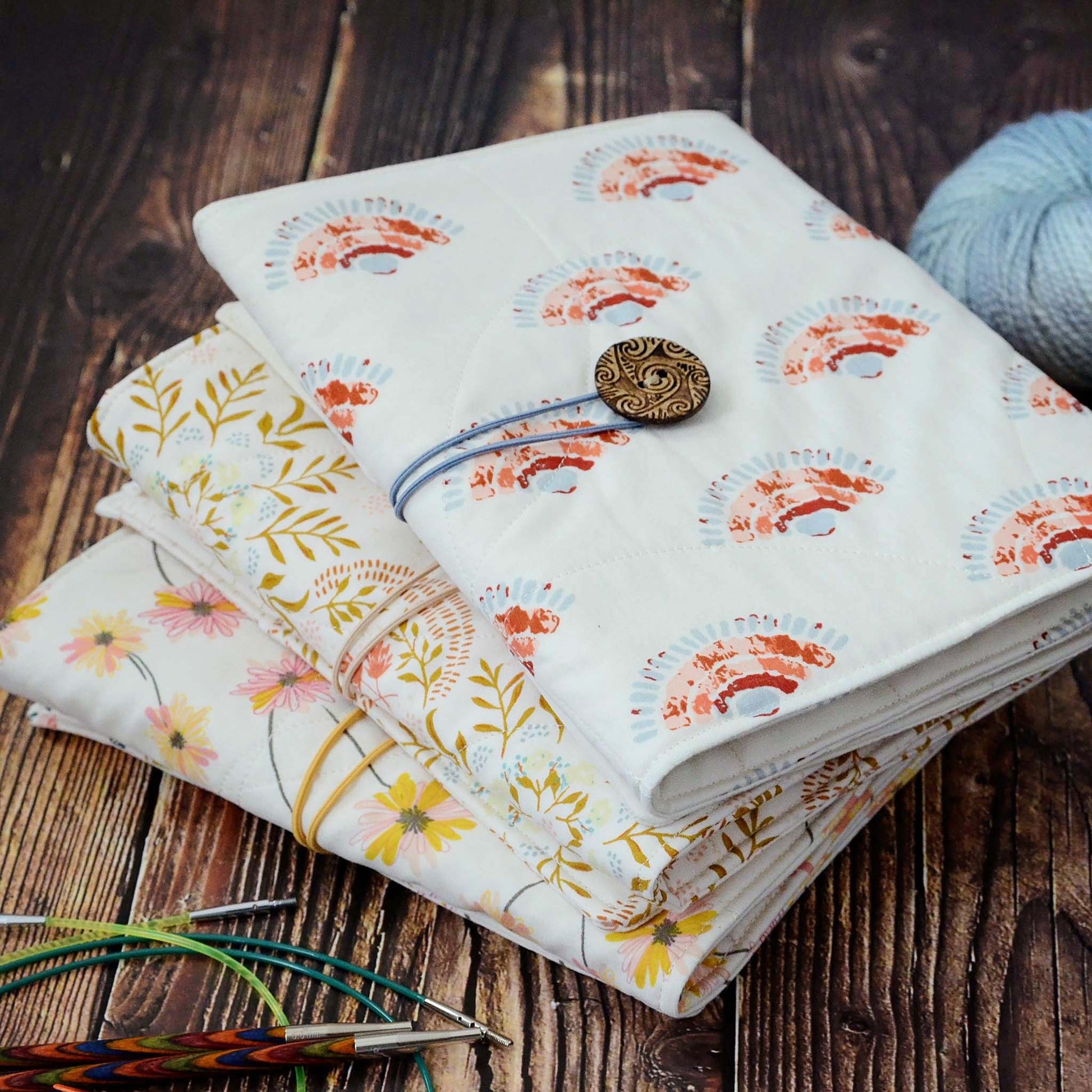 Quilted knitting needle wraps in premium Art Gallery Fabric.  Three different designs, all with an elastic and button closure.  Made in Canada by Yellow Petal Handmade.