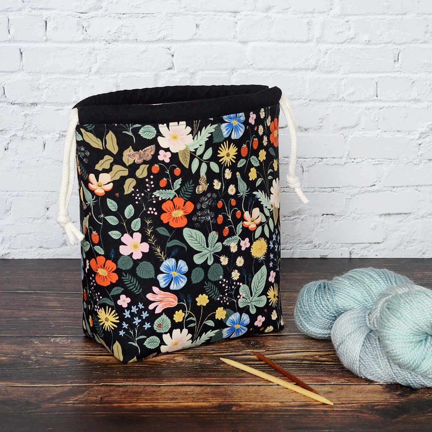 Black floral knitting project bag in Strawberry Fields fabric by Rifle Paper Co.  Lined in a pretty pink floral with pockets.  Made in Canada by Yellow Petal Handmade.